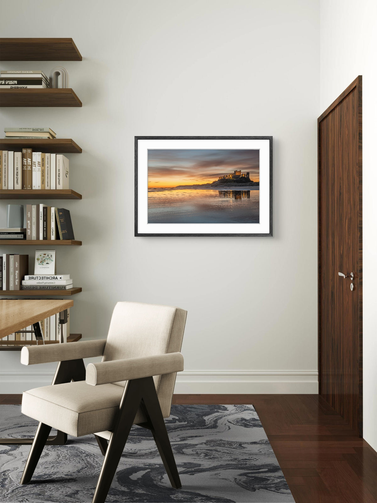 Modern interior with a chair, bookshelf, and framed picture on the wall.