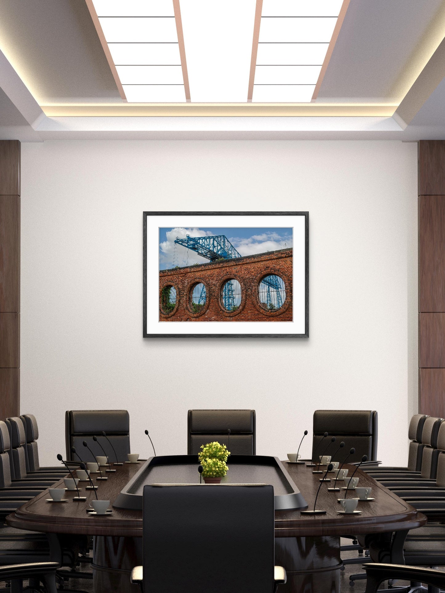 Modern conference room with a large table and chairs, framed picture on the wall.
