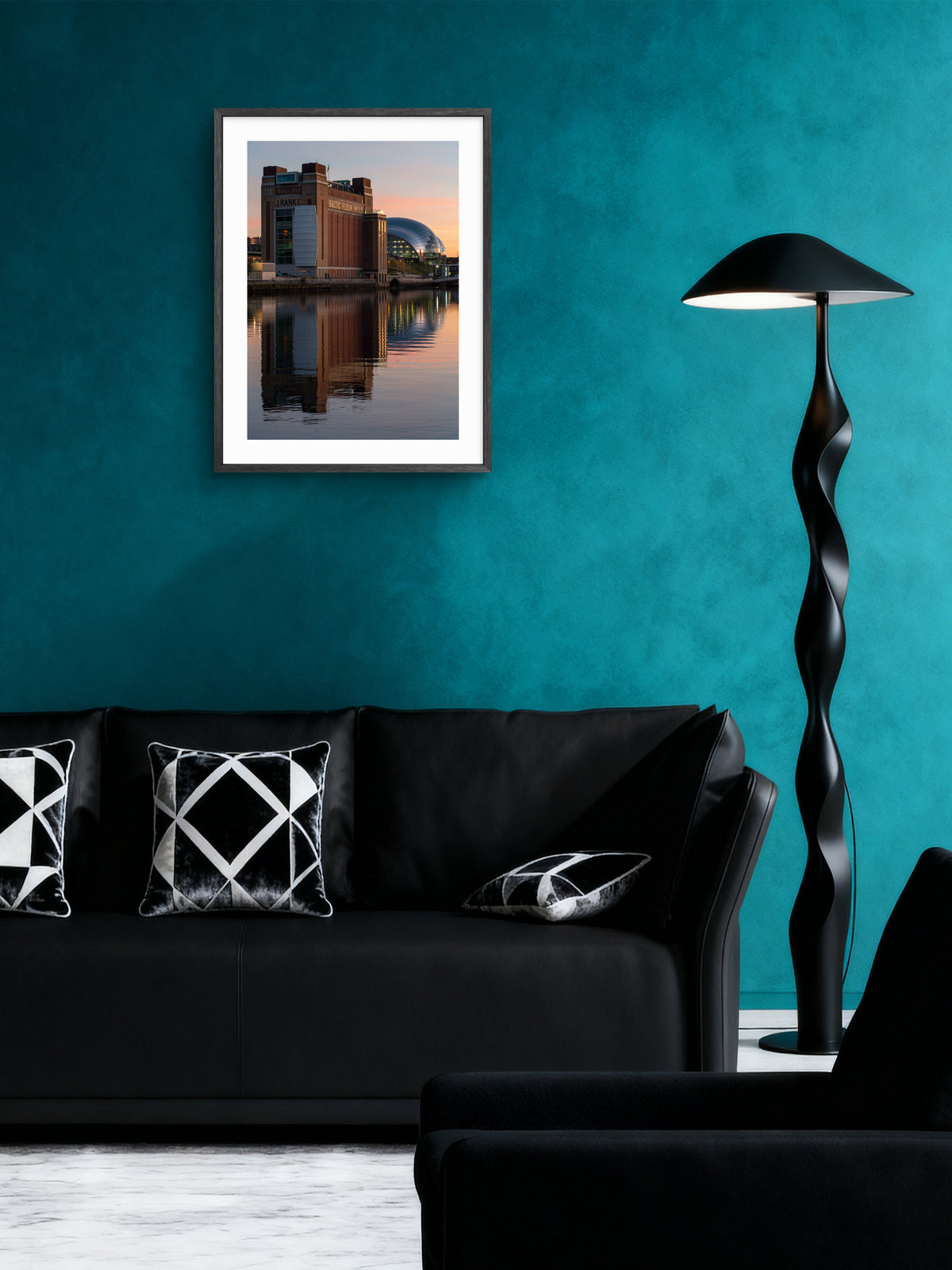 Baltic and Glasshouse wall art displayed above a black sofa on a teal wall.