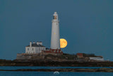 Lighthouse on an island with a full moon in the sky