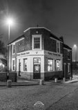 Black and white photograph of a pub named 'Free Trade Inn' at night.