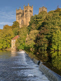 Historic cathedral with a dam and waterfall in the foreground