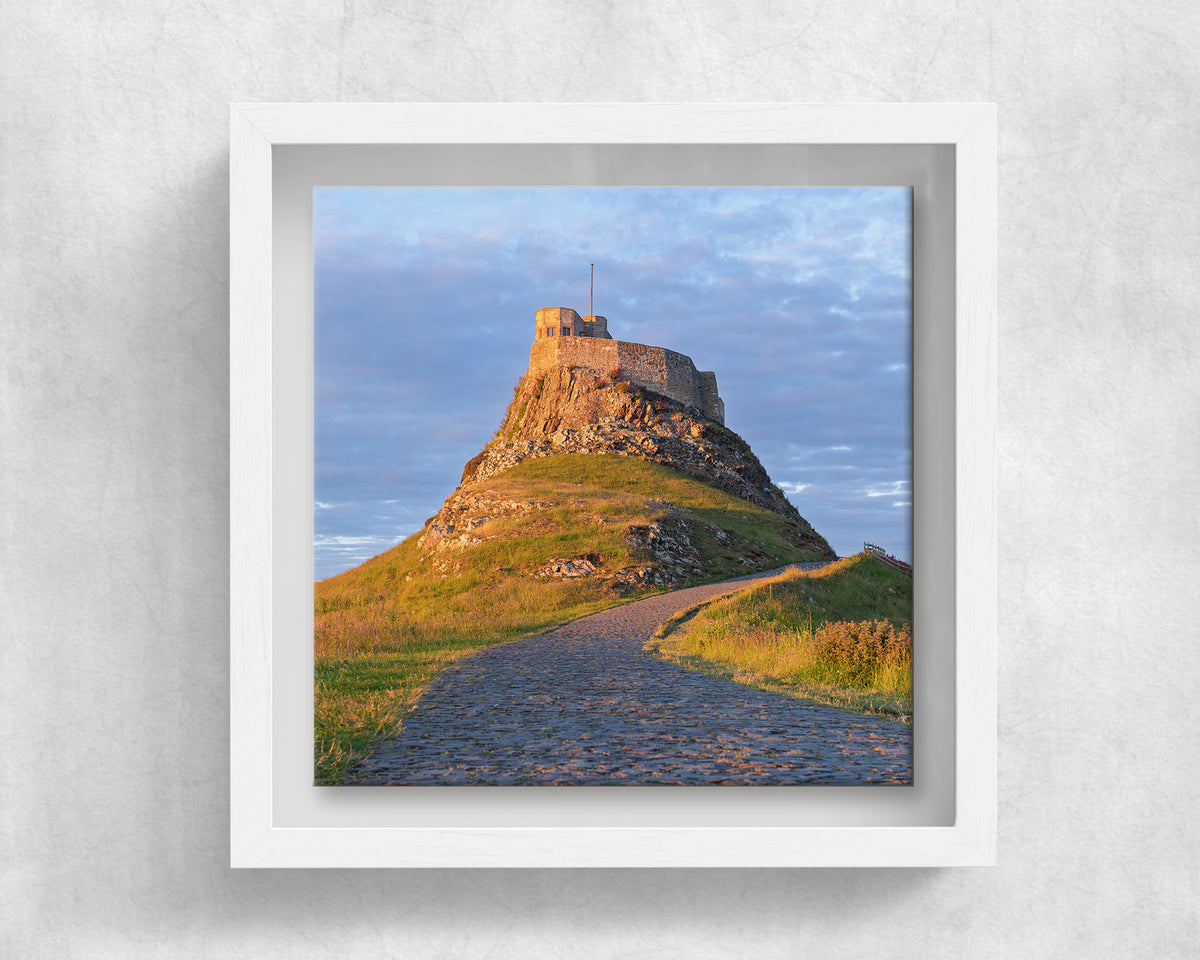 Lindisfarne Castle on an 8×8 inch ceramic tile in a white box frame, front view