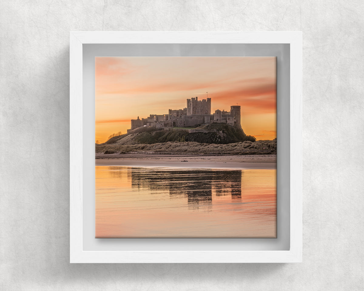 Bamburgh Castle at Sunrise on an 8×8 inch ceramic tile in a white box frame, front view