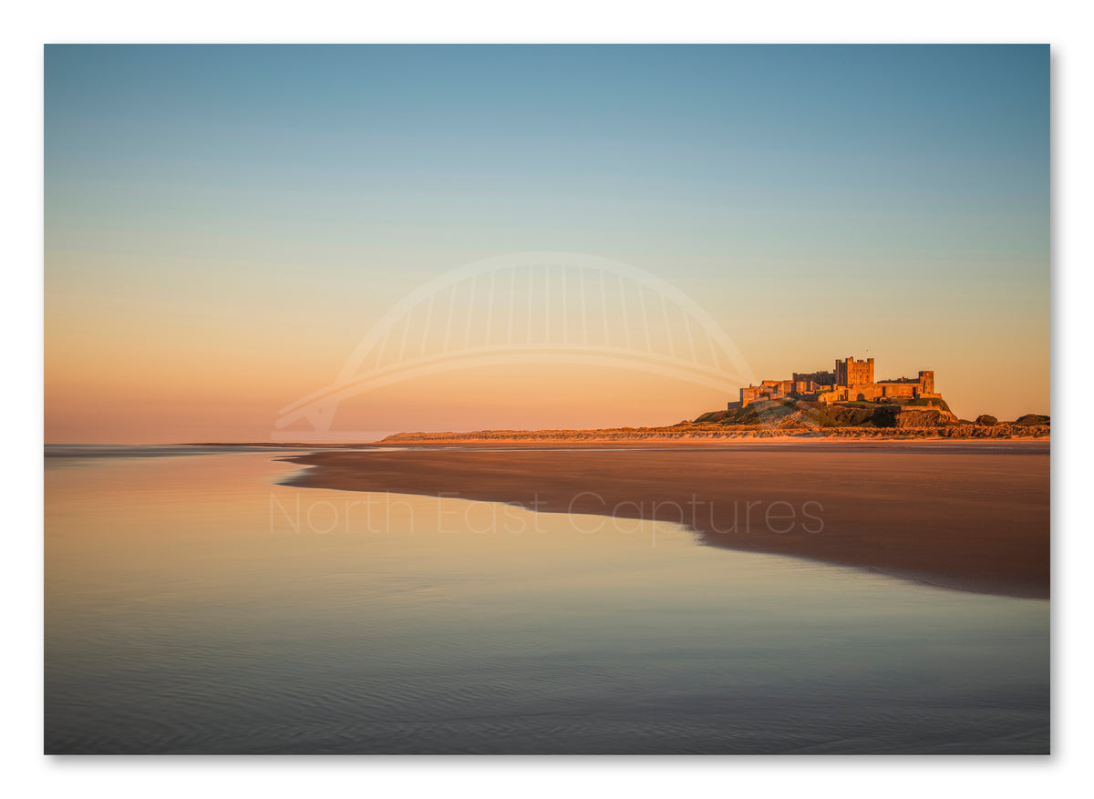 Bamburgh Castle and beach at sunset shown as a canvas print.