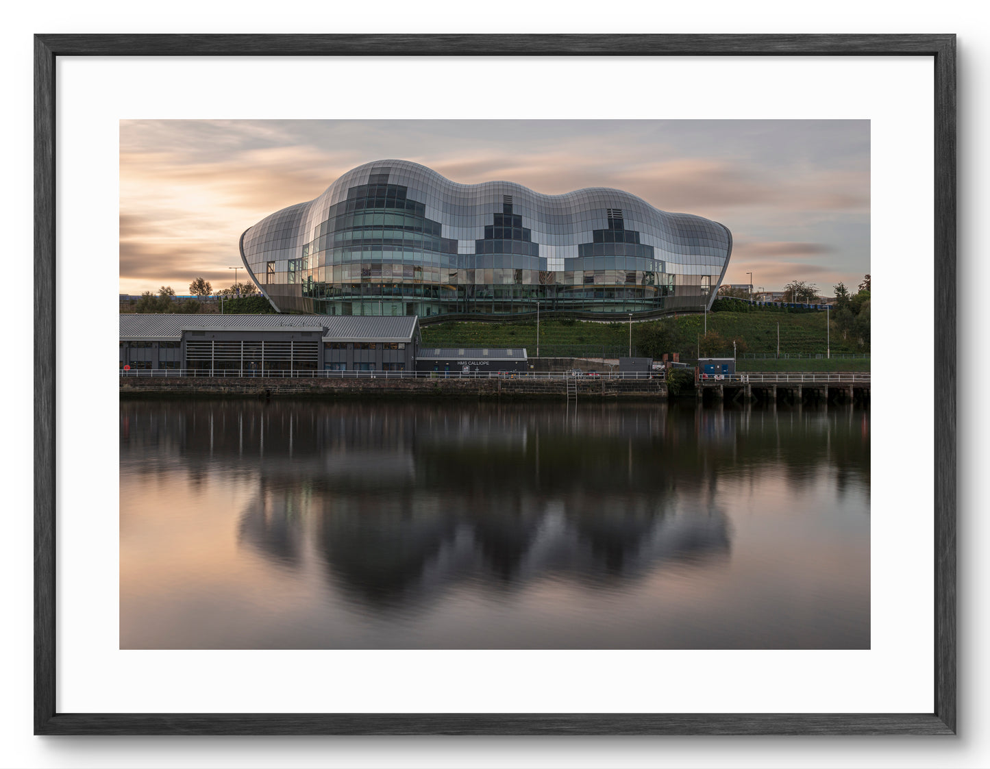 The Glasshouse (Sage) Gateshead - Reflecting on The River Tyne at Sunrise - Gateshead shown as a framed photographic print.