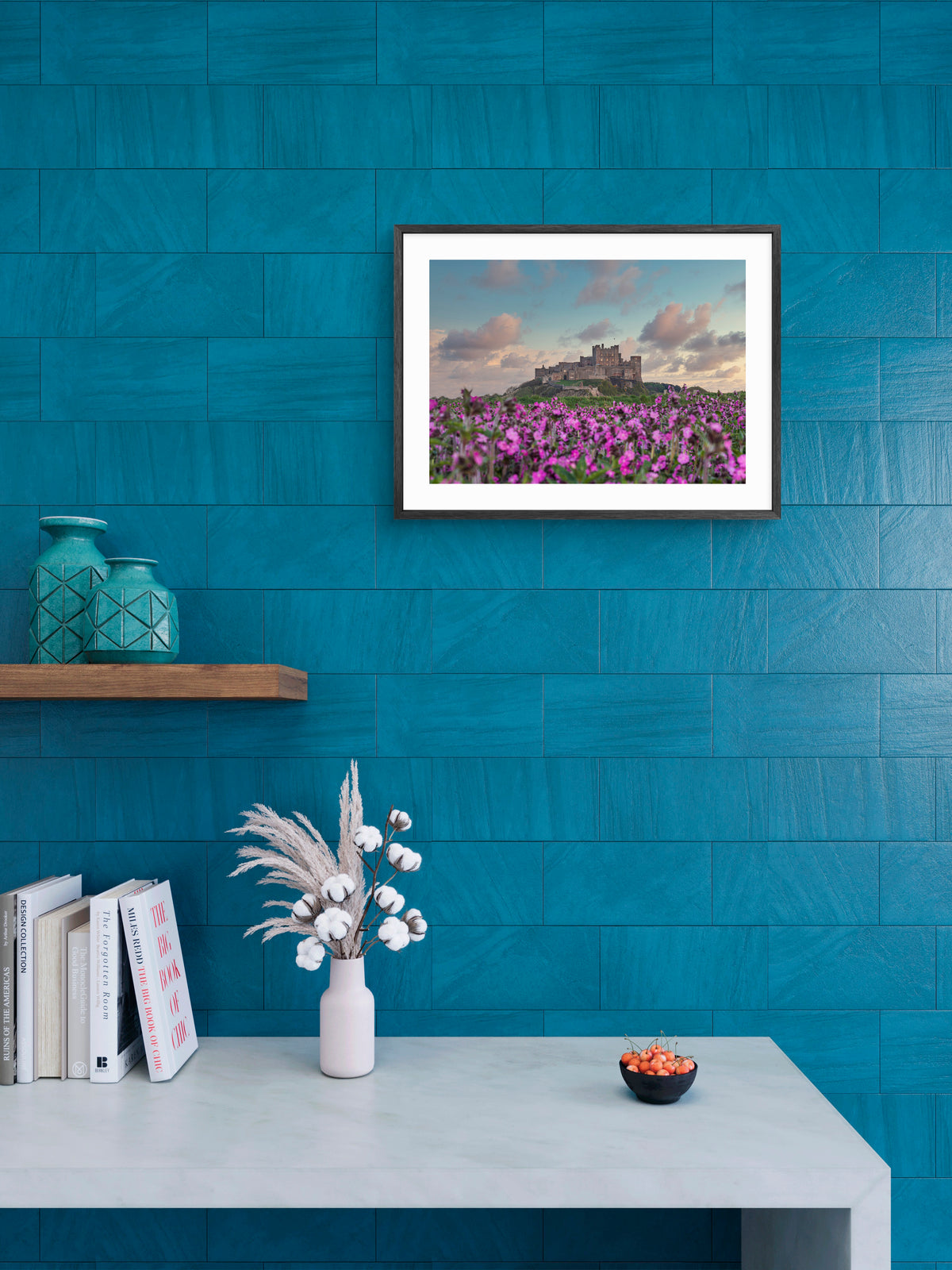 Bamburgh Castle beyond a field of flowers wall art displayed in a styled room setting.