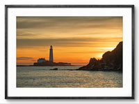 Lighthouse on an island with a colorful sunset sky, framed picture.