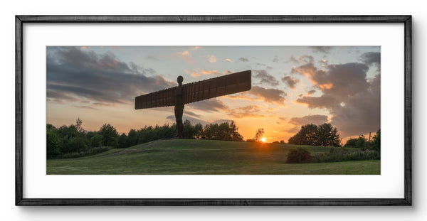 Framed artwork of the Angel of the North sculpture against a sunset sky.