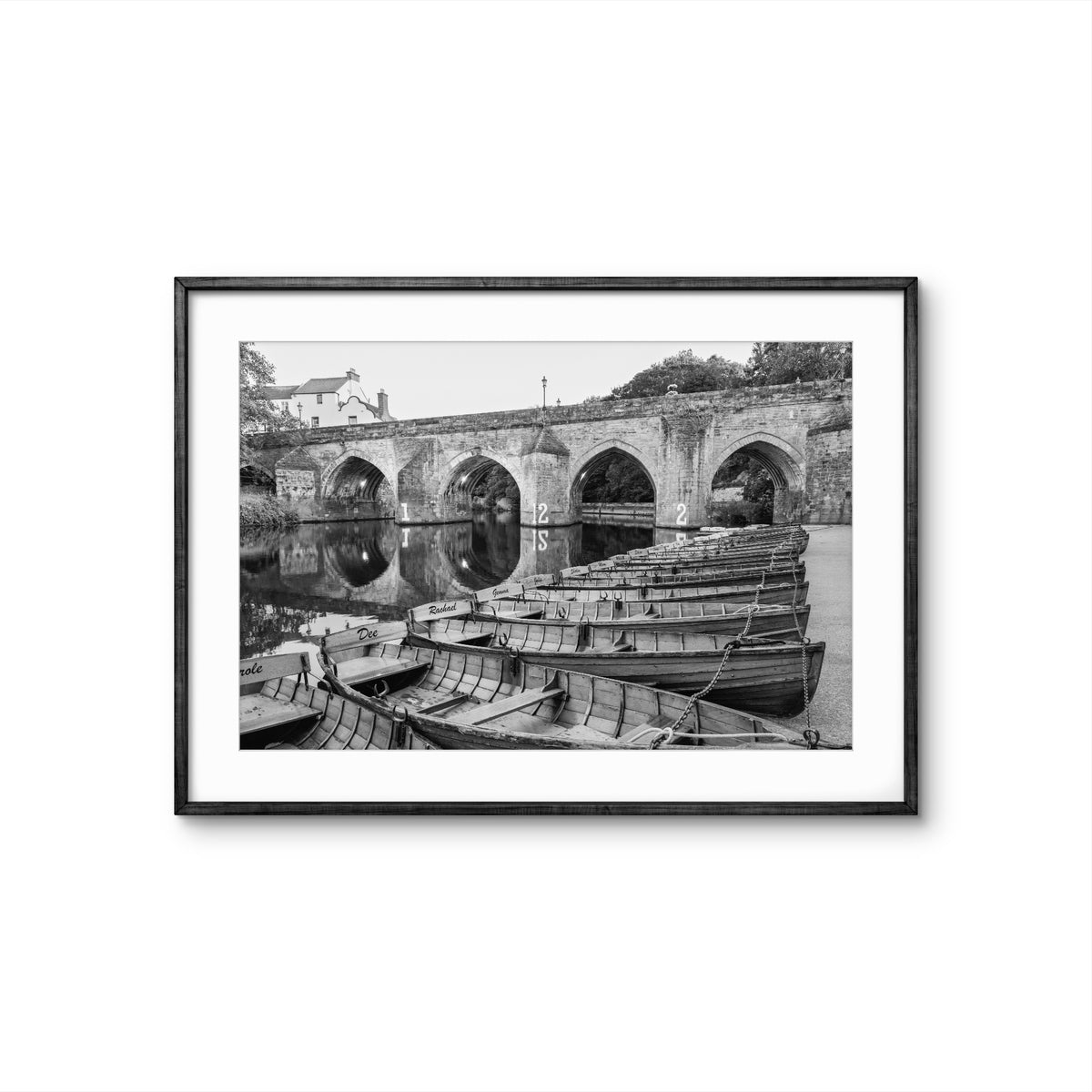 Framed black and white photograph of a stone bridge with boats below