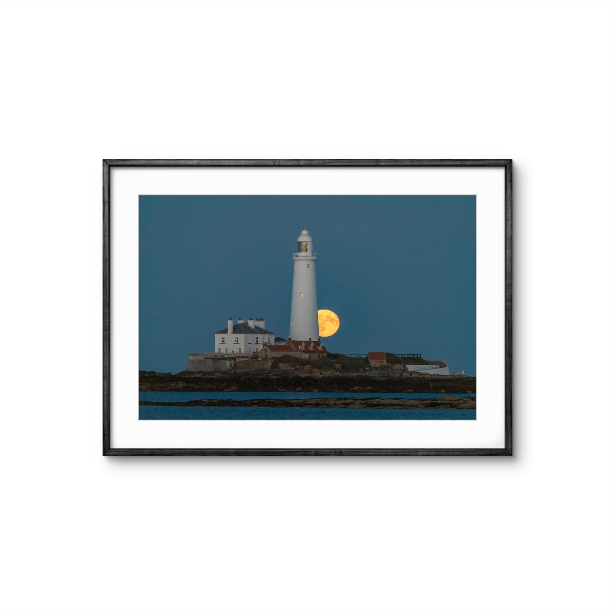 Framed photograph of a lighthouse with a moonlit sky