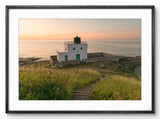 Lighthouse on a cliff with ocean view during sunset
