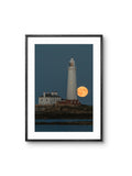 Framed photograph of a lighthouse with a full moon in the background