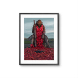 Framed artwork of a statue covered in red poppies with a black frame.