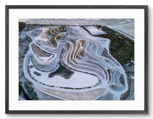Aerial view of a frozen landscape with wavy ice patterns.
