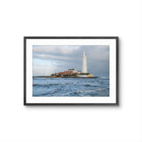Framed photograph of a lighthouse on an island with choppy waters and a cloudy sky.