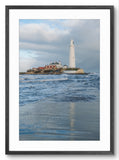 Framed photograph of a lighthouse on an island with blue water and sky.