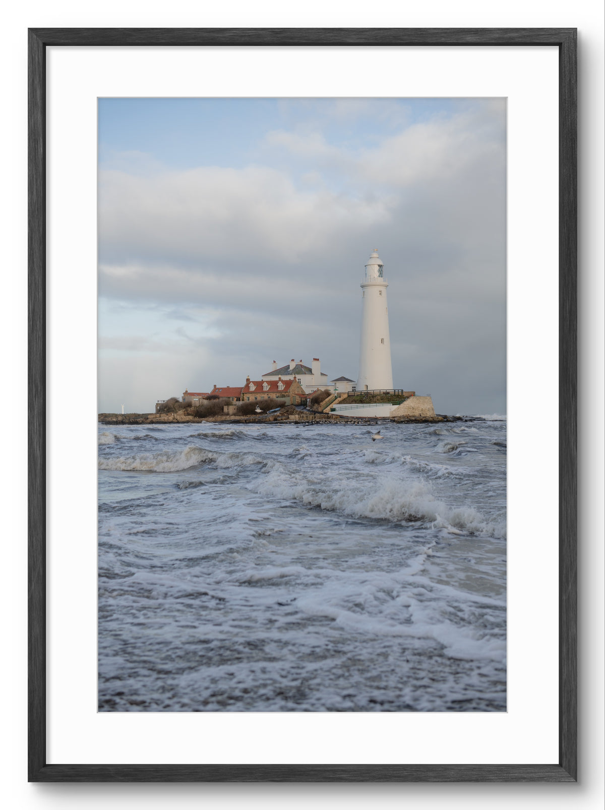 Lighthouse on a rocky island with waves in the foreground, framed picture.
