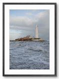 Lighthouse on a rocky island with waves in the foreground, framed picture.