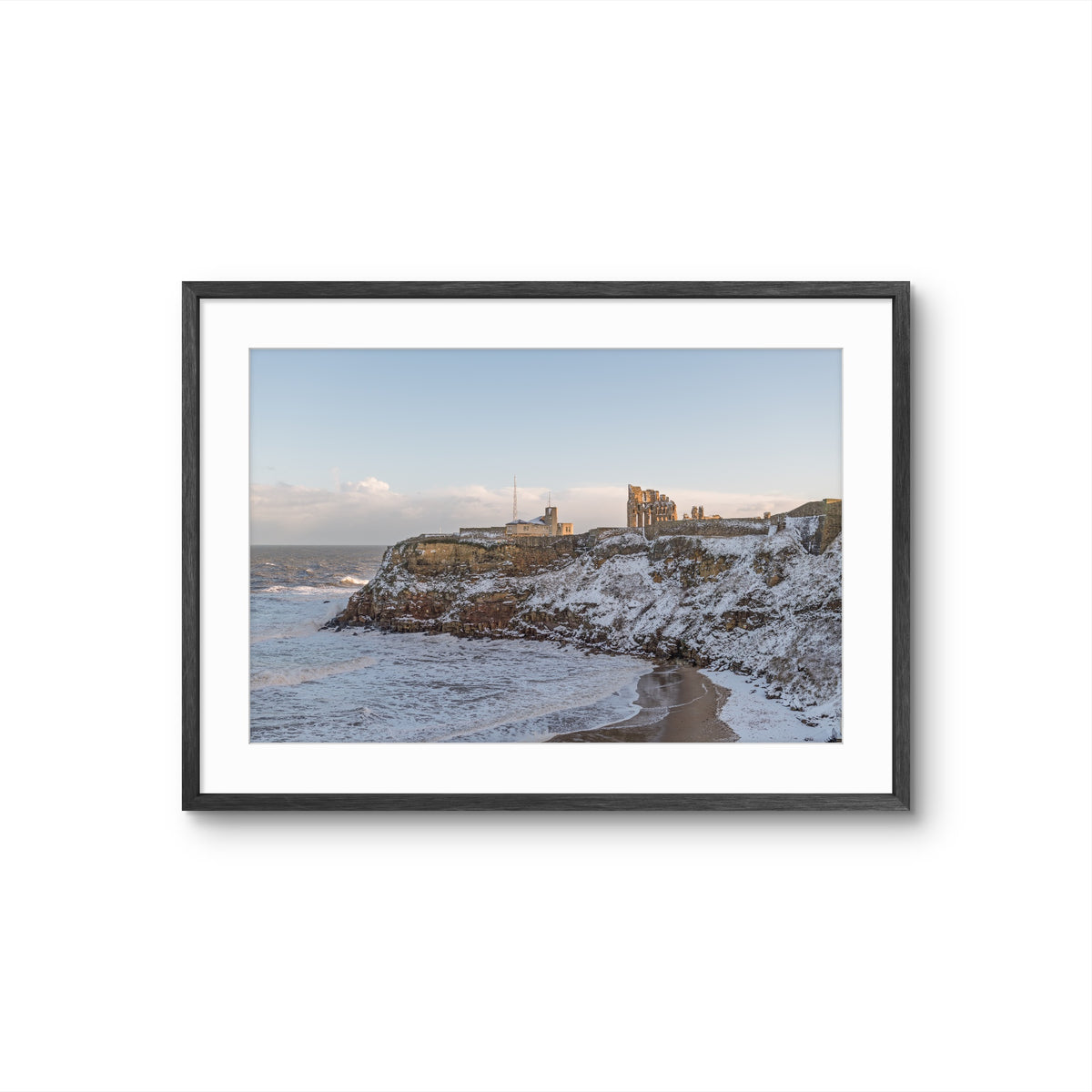 Framed photograph of a coastal landscape with cliffs and ocean.
