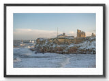 Framed photograph of a coastal scene with a castle on a cliff overlooking the sea.