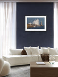 Living room with a white sofa, coffee table, and framed picture of a lighthouse on a blue wall.