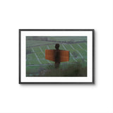 Framed artwork of Angel of The North against a green landscape.