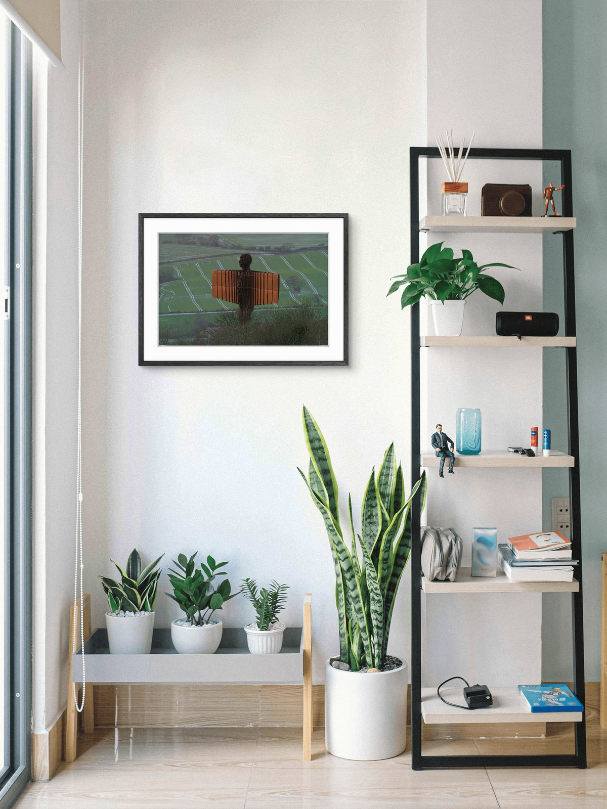 Modern interior with a shelf, plants, and framed picture on a wall.