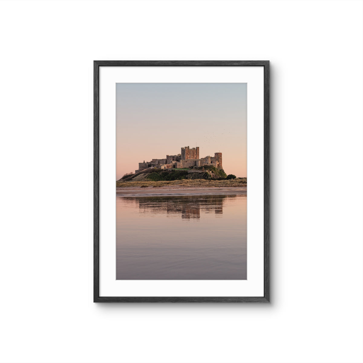Framed photograph of a castle on an island with a reflective water surface and pastel sky.