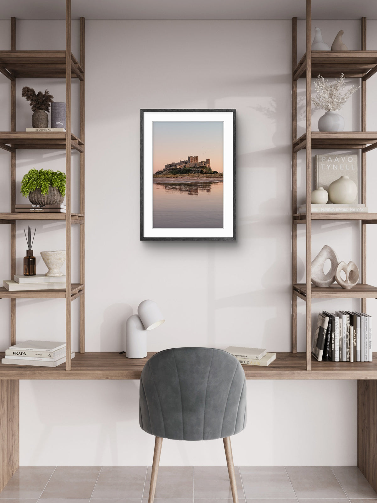 Framed artwork of a castle on a lake in a modern room with shelves and a chair.