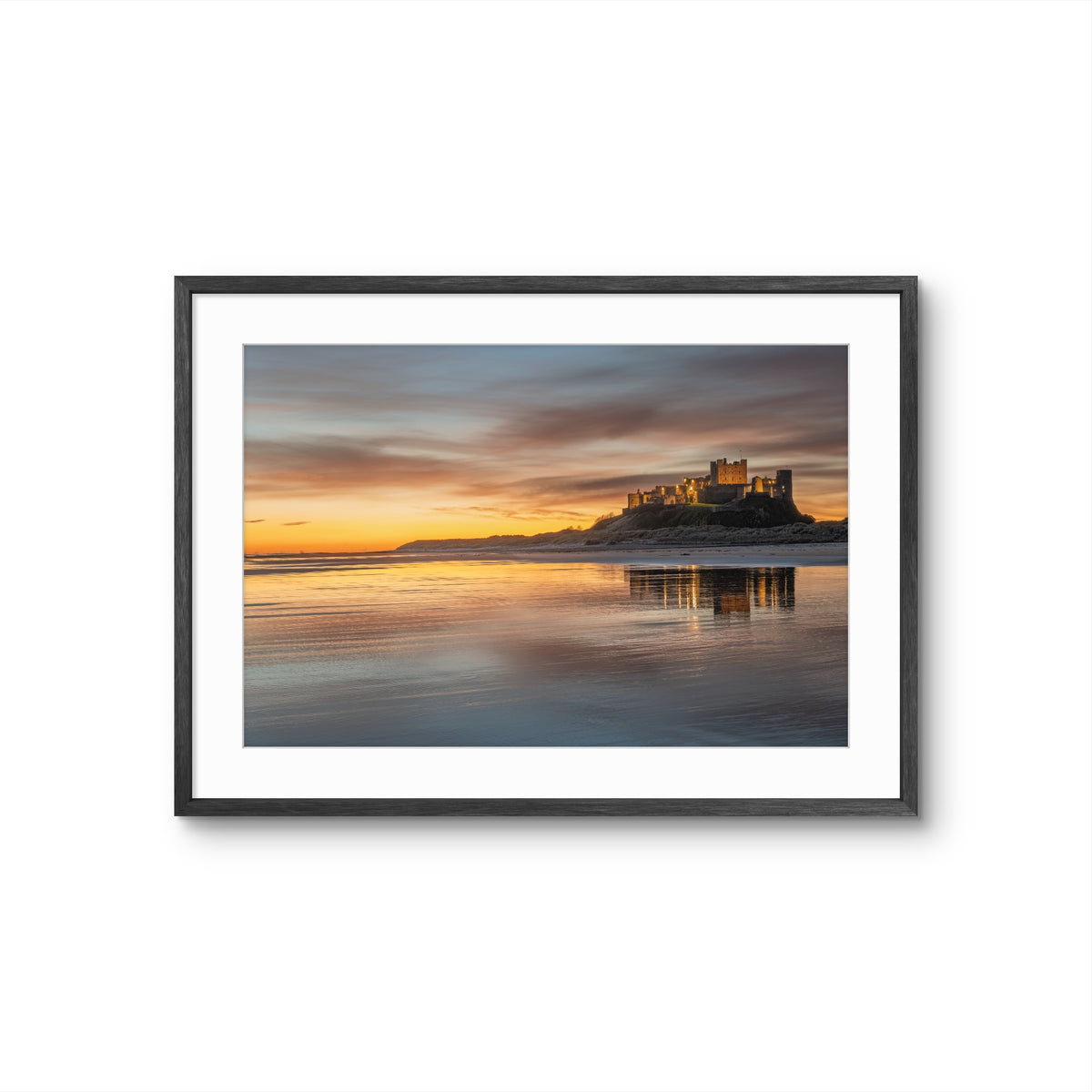 Framed photograph of Bamburgh Castle at golden sunrise with reflections on the Northumberland coast.