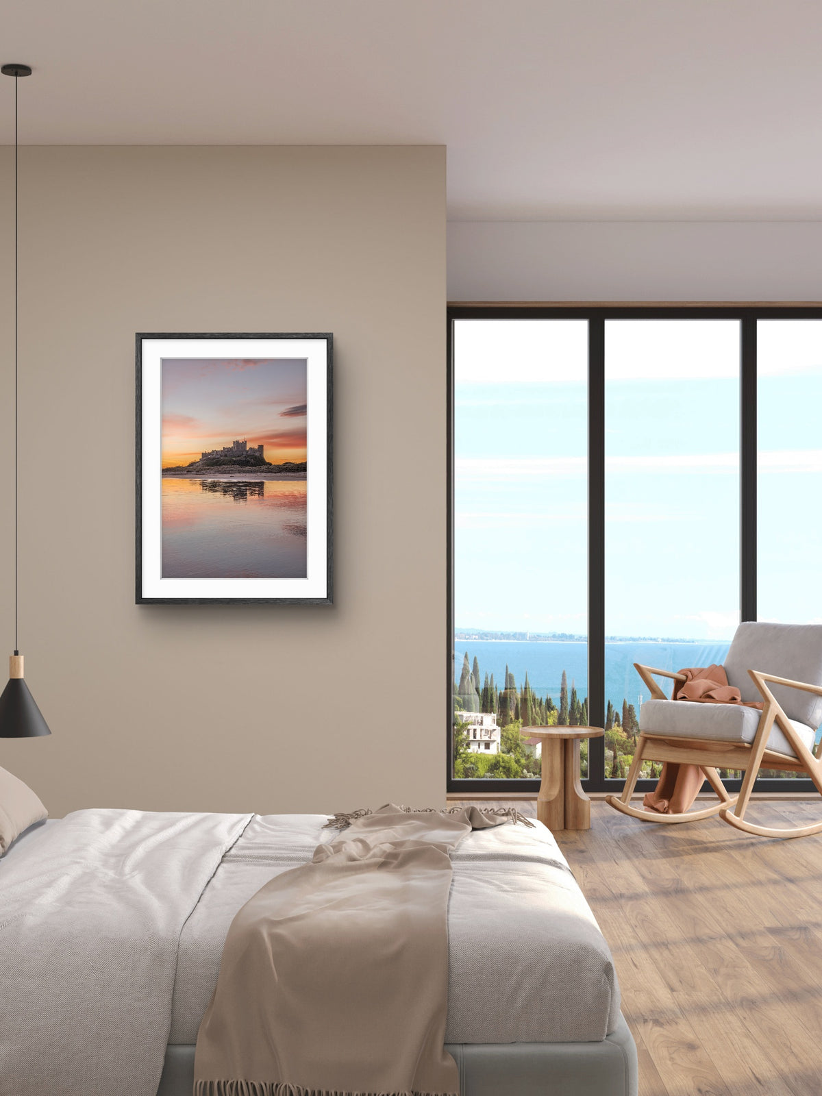 Portrait photograph of Bamburgh Castle at sunrise reflecting in wet sand with soft gold, pink and blue sky tones, Northumberland coast
