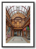 Interior of a grand shopping arcade with wooden architecture and glass ceiling.
