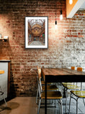 Restaurant interior with brick wall, framed picture, and wooden table.