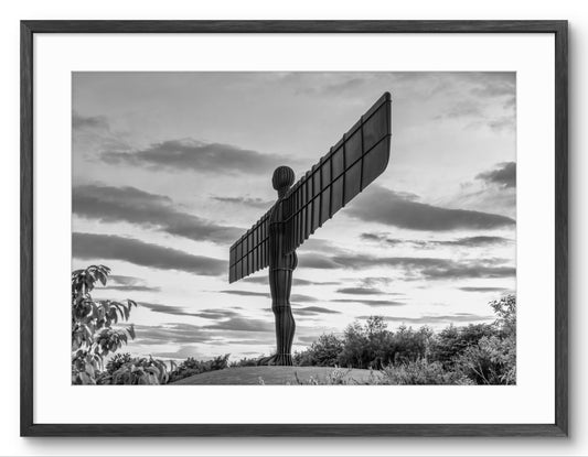 Black and white photograph of the Angel of the North sculpture against a cloudy sky.