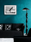 Modern living room with teal walls, black sofa, and decorative lamp.