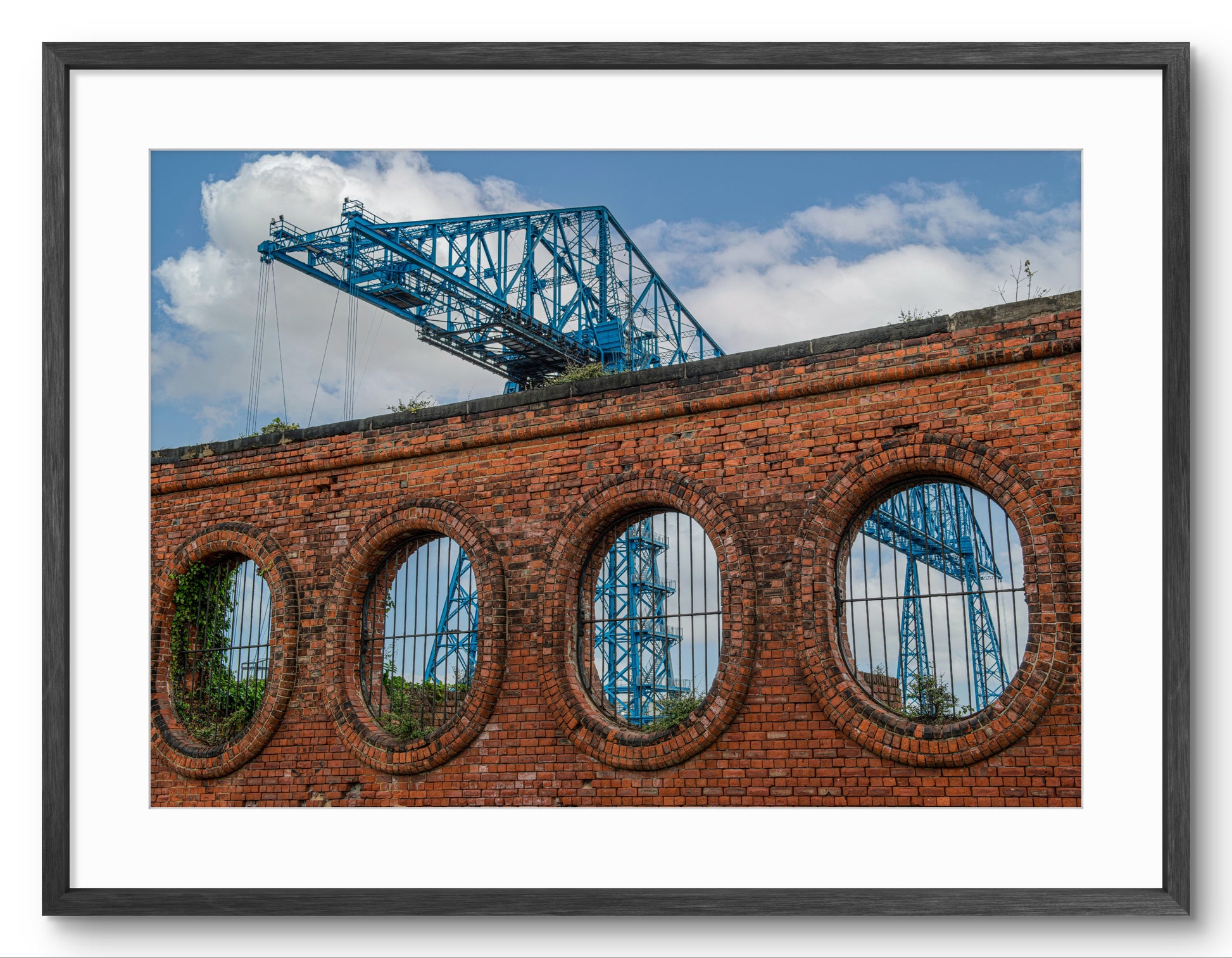 Blue crane reflected in a brick building with arched windows against a blue sky.