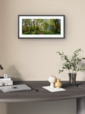 Framed nature print on a wall above a desk with decor items.