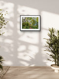 Framed nature print on a wall with plants around