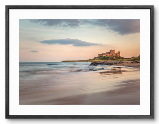 Bamburgh Castle reflected on the beach shown as a framed photographic print.