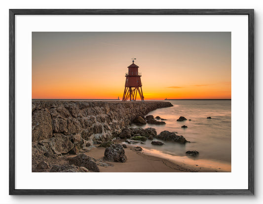 Herd Groyne Lighthouse - Golden Sunrise - South Shield shown as a framed photographic print.