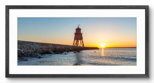 Herd Groyne Lighthouse Sun Reflections panoramic print — black frame and white mount