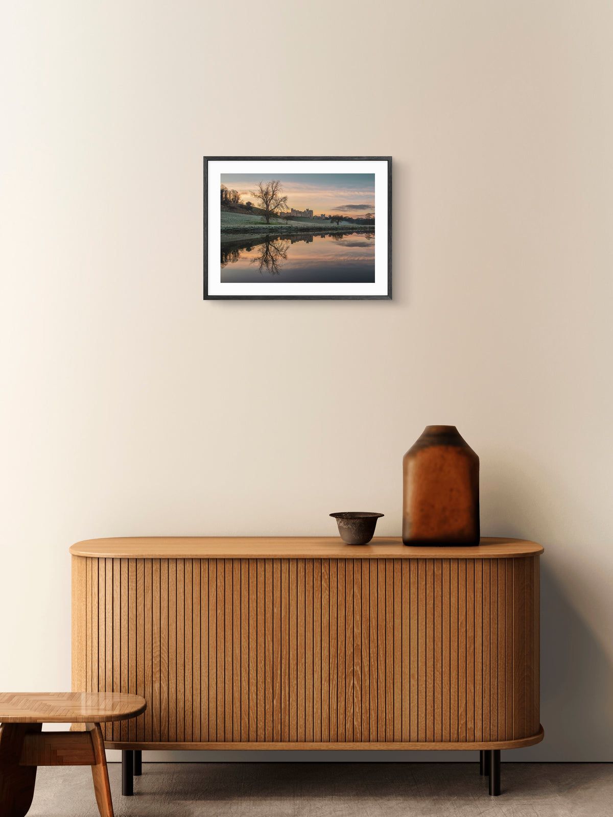 Alnwick Castle and River Aln wall art displayed above a wooden sideboard.