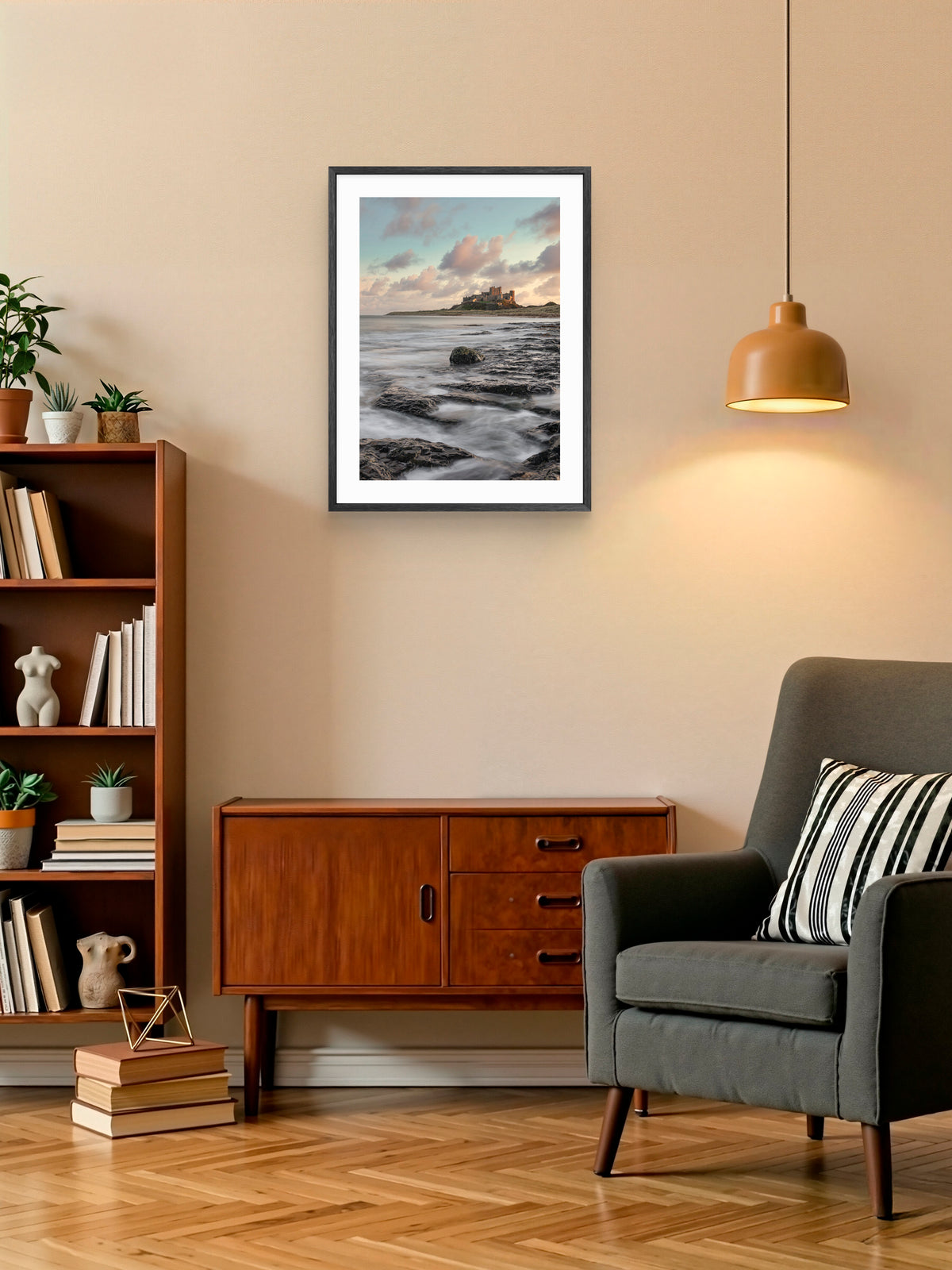 Waves on rocks at sunset near Bamburgh Castle wall art displayed in a styled room setting.