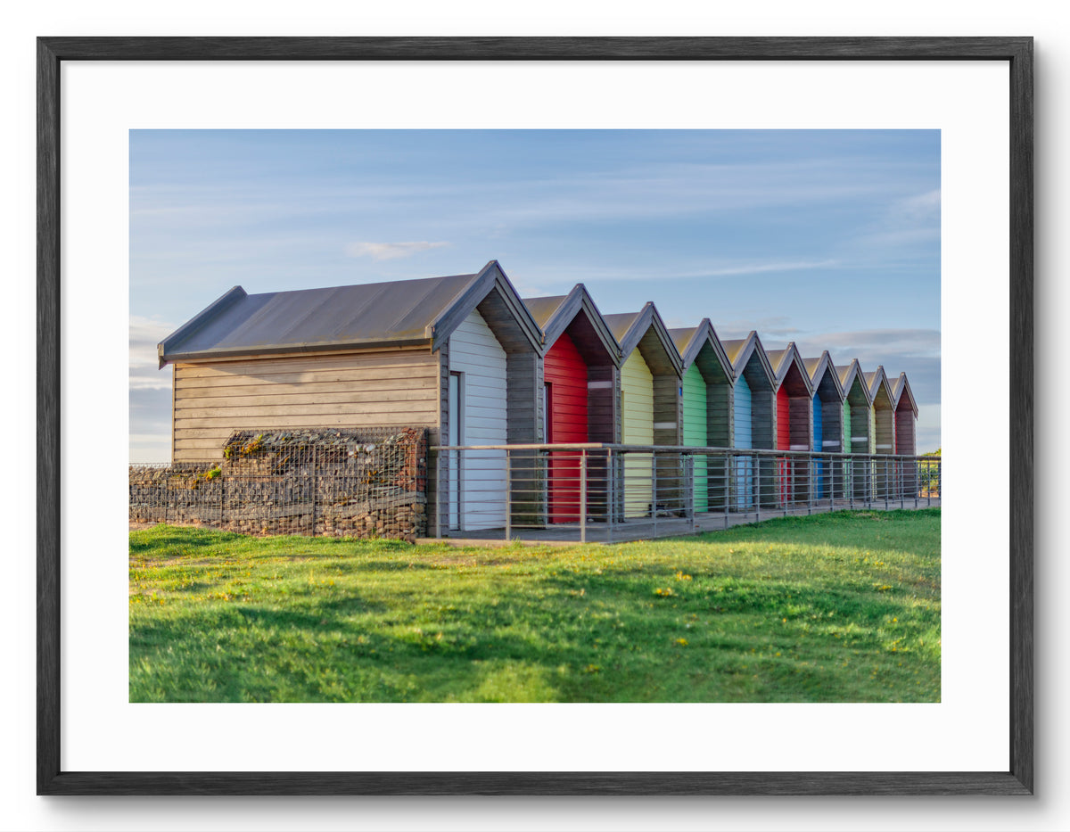 Colourful beach huts at Blyth shown as a framed photographic print.