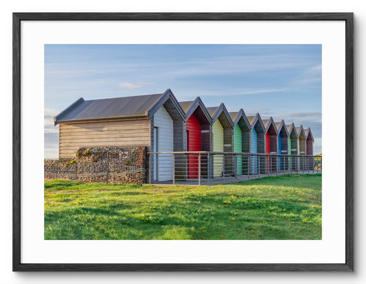 Colourful beach huts at Blyth shown as a framed photographic print.
