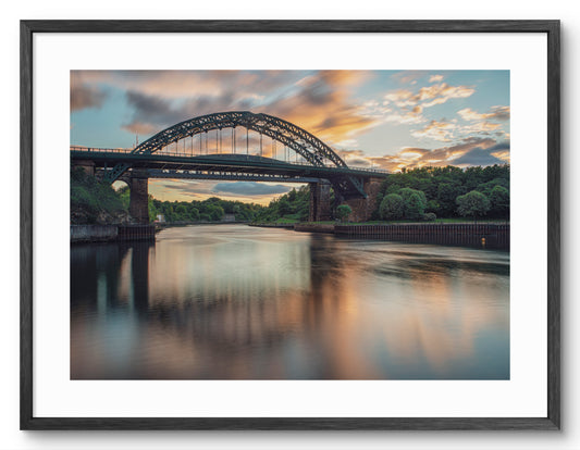Wearmouth Bridge - Reflecting on The River Wear - Sunderland shown as a framed photographic print.