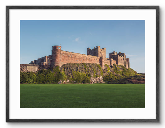 Bamburgh Castle viewed from the cricket field shown as a framed photographic print.