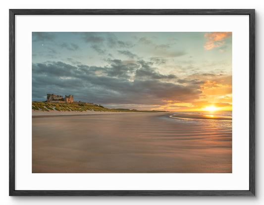 Bamburgh Castle at sunset shown as a framed photographic print.