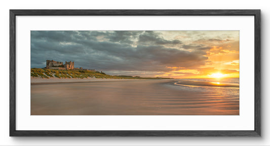 Bamburgh Castle & Beach at Sunrise panoramic print — black frame and white mount